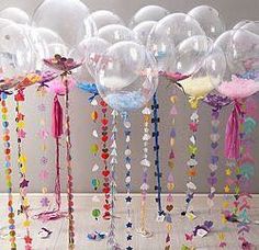 balloons and streamers are hanging from the ceiling in front of a wall with butterflies