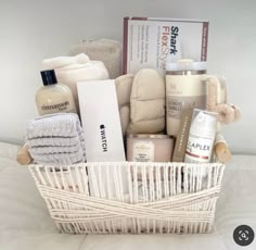 a white basket filled with baby items on top of a bed