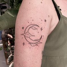 a woman with a tattoo on her arm that has the moon and stars in it