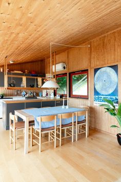 a kitchen and dining area with wood paneling on the walls, hardwood floors and ceiling