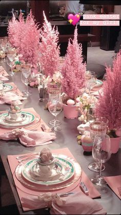 the table is set with pink flowers and place settings