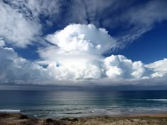 the sky is filled with clouds over the ocean