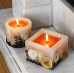 two candles sitting on top of a counter