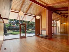 an empty room with wooden floors and large windows