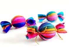 three colorful striped bows are sitting on a white surface, with one bow tied to the other