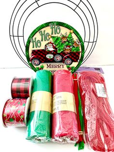 christmas wrapping supplies are displayed in front of a circular metal sign that reads, merry