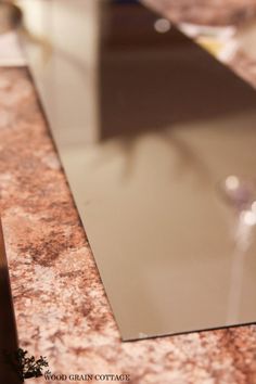 a close up view of a marble counter top with an empty wine glass on it