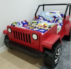 a red jeep bed in the corner of a room