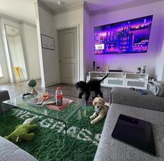 a living room filled with furniture and a dog on top of a rug in front of a glass coffee table