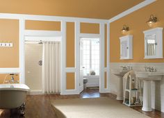 a bathroom with blue and white walls, wood floors and a claw foot bathtub