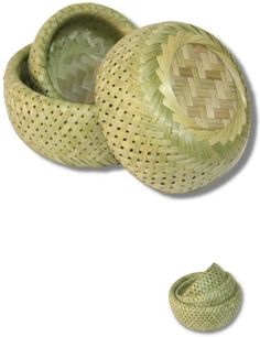 two woven baskets sitting next to each other on top of a white surface with a green hat in the middle