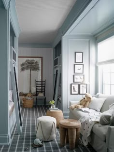 a living room filled with lots of furniture and pictures on the wall next to windows