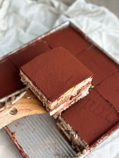 there is a chocolate cake in the pan with a wooden spatula