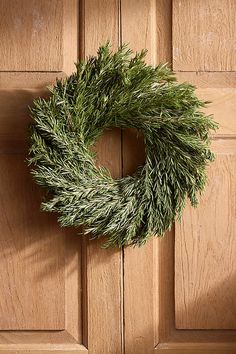 a wreath hanging on the side of a wooden door