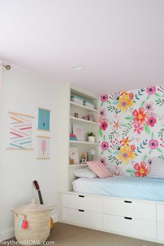 a bedroom with floral wallpaper and built in bookshelves