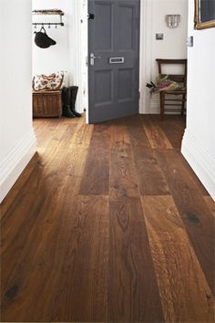 an open door leading to a hallway with wooden floors