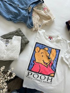 Fun vintage graphic Winnie the Pooh tee from the 90s with large graphics on the front. So sweet. Light wear on the graphics. In good vintage condition. Measurements taken while item is laid flat. Measurements: bust: 21" length: 24" Tag size: No tag size Fabric: No fabric details Model is 5'6 with a waist 26" and hips 36" FOLLOW US ON INSTAGRAM @theweathereddaisy FOR RELEASE DATES + STORY SALES! SHOP OUR WEBSITE theweathereddaisy.com FOR EVEN MORE EXCLUSIVE APPAREL. Disney Graphic Tees Vintage, Winnie Pooh T Shirt, Vintage Disney Clothes, Vintage Disney Outfits, 90s Graphic Tees Vintage, Pooh Shirt, Surprise Az, Graphic Tees Vintage, Thrift Finds