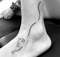 a black and white photo of a woman's foot with a tattoo on it