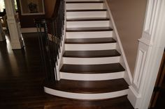 there is a white and brown staircase in the house