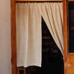 an open window with a white curtain hanging from it's side