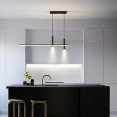 a kitchen with black counter tops and stools next to an island in the middle