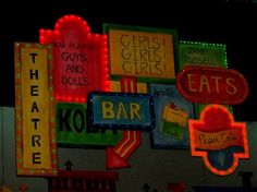 many signs are lit up on the side of a building