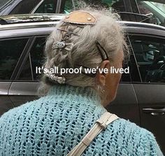 an old woman with glasses looking out the window in front of her car that says it's all proof we've lived