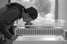 a man bending over to kiss a baby in a crib