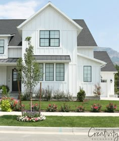 a large white house sitting on top of a lush green field