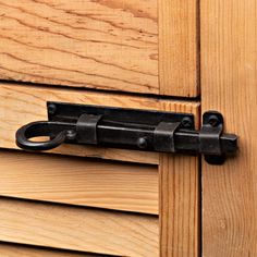 a close up of a wooden door with an iron handle on the outside of it