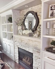 a living room filled with furniture and a fire place under a large mirror on the wall