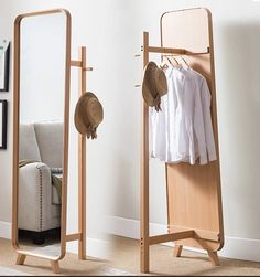 a mirror and clothes rack with hats on it in front of a wall mounted mirror