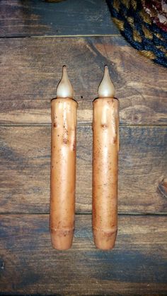 two brown salt and pepper shakers sitting on top of a wooden table next to a rug