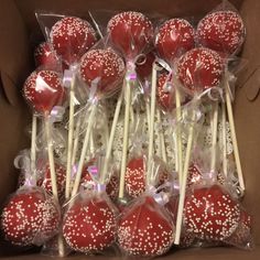 a box filled with red and white lollipops covered in sprinkles