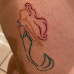 a woman's leg with a mermaid tattoo on it