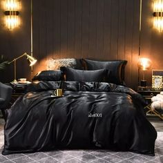 a bed with black sheets and pillows in a dark colored room next to two lamps