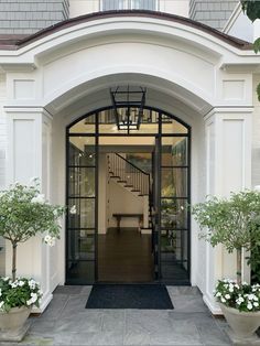 an entrance to a home with potted plants