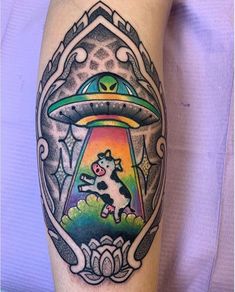 a person with a tattoo on their arm that has an alien ship in the middle