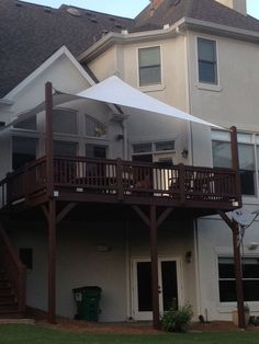 a large house with a white awning over it's balcony and stairs leading to the second floor