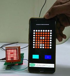 a person is holding up a cell phone with an electronic circuit board on the screen