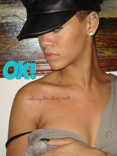 a woman with a hat on her head has a tattoo on her shoulder that says love