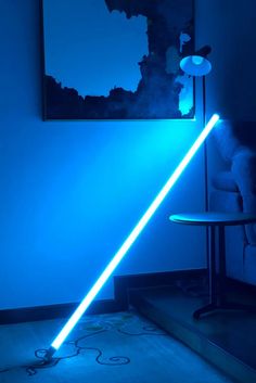 a blue room with a light saber on the floor and a chair in front of it