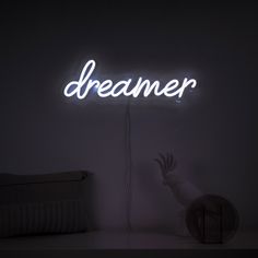 a neon sign that reads,'dreamer'on the wall next to a crib