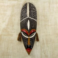 an african mask hanging on the wall