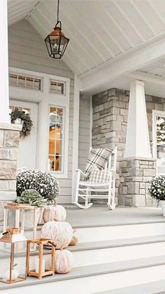 front porch decorated for fall with white pumpkins and baby's breath flowers on the steps