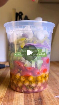 a plastic container filled with food sitting on top of a wooden table