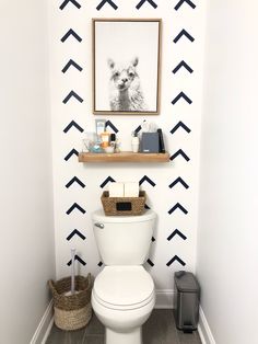 a white toilet sitting in a bathroom next to a wall with black arrows on it