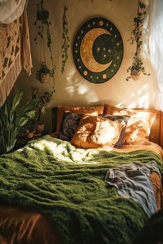 a bed with green blankets and pillows in a room next to a wall hanging plant