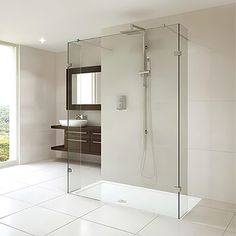 a large bathroom with a walk in shower next to a sink and mirror on the wall