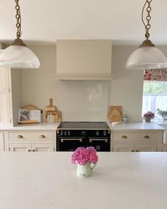 a kitchen with an island and two lights hanging from the ceiling over the stove top